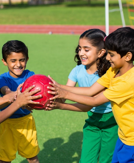 Children sharing red ball